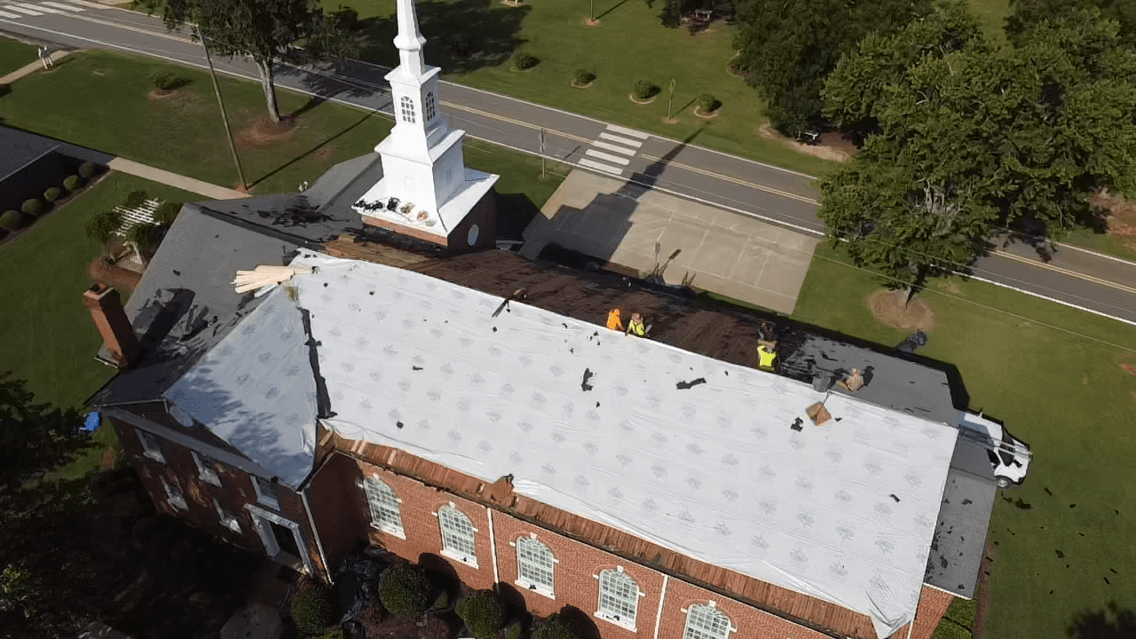 church with people on top working on the roof construction