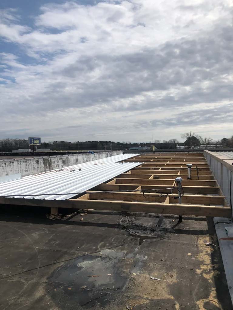 Alliance Roofing building a new roof on top of an old commercial roof