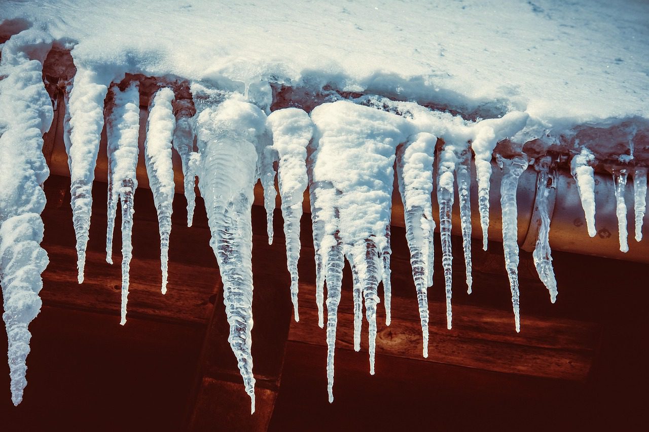 A roof with heavy snow and icicle buildup