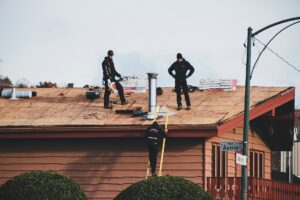 Roofers standing on a newly installed asphalt shingle roof