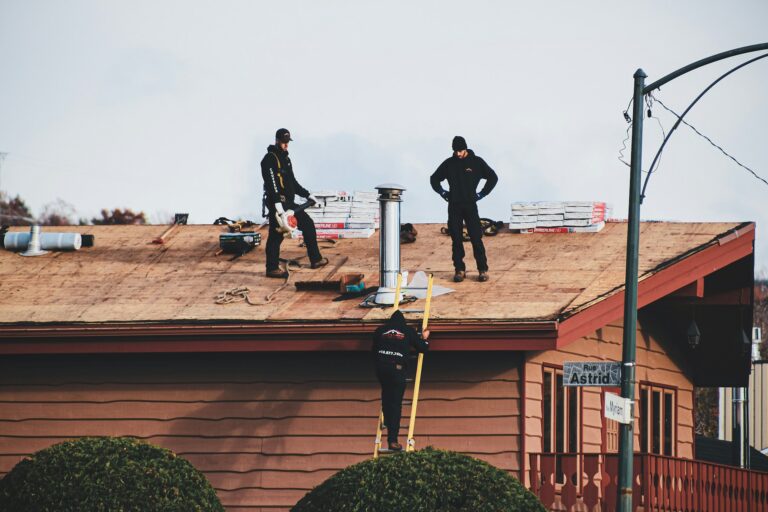 Roofers standing on a newly installed asphalt shingle roof