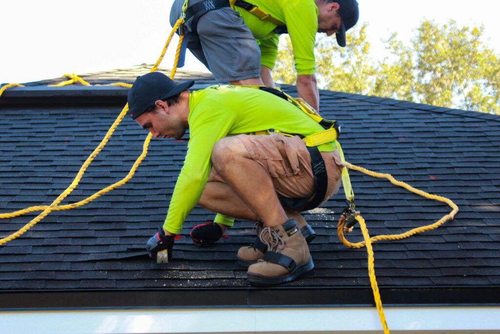 Two young men working on the roof of a house
